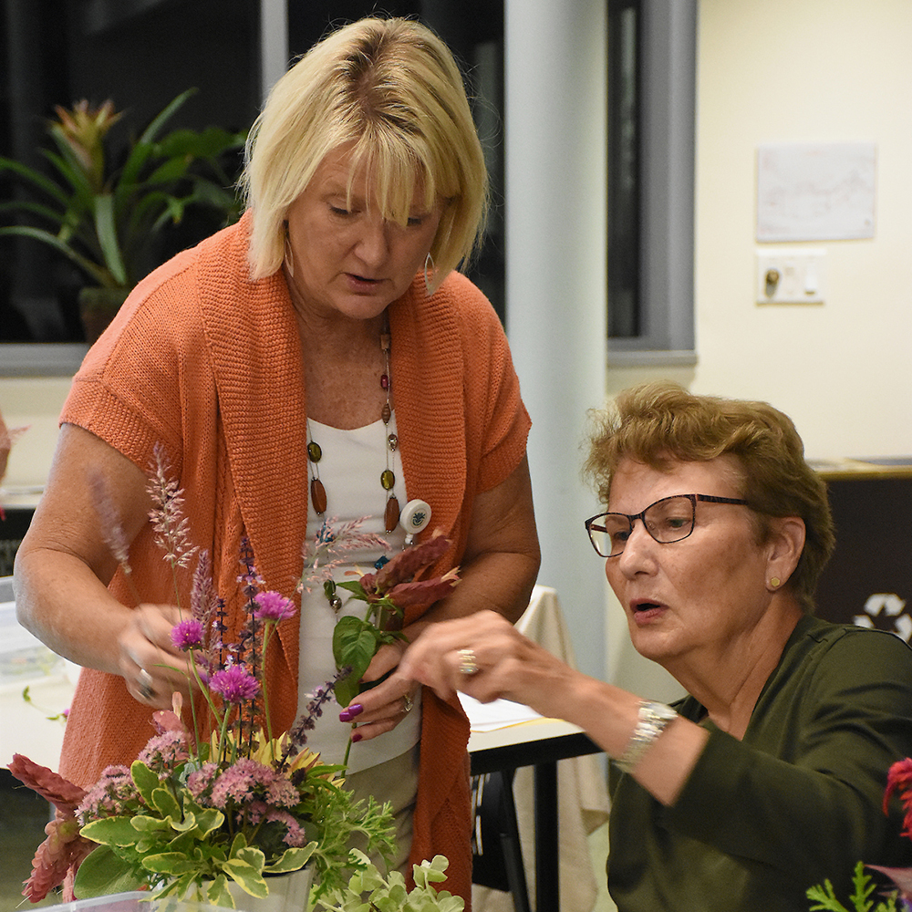Instructor helping participant with flower arranging